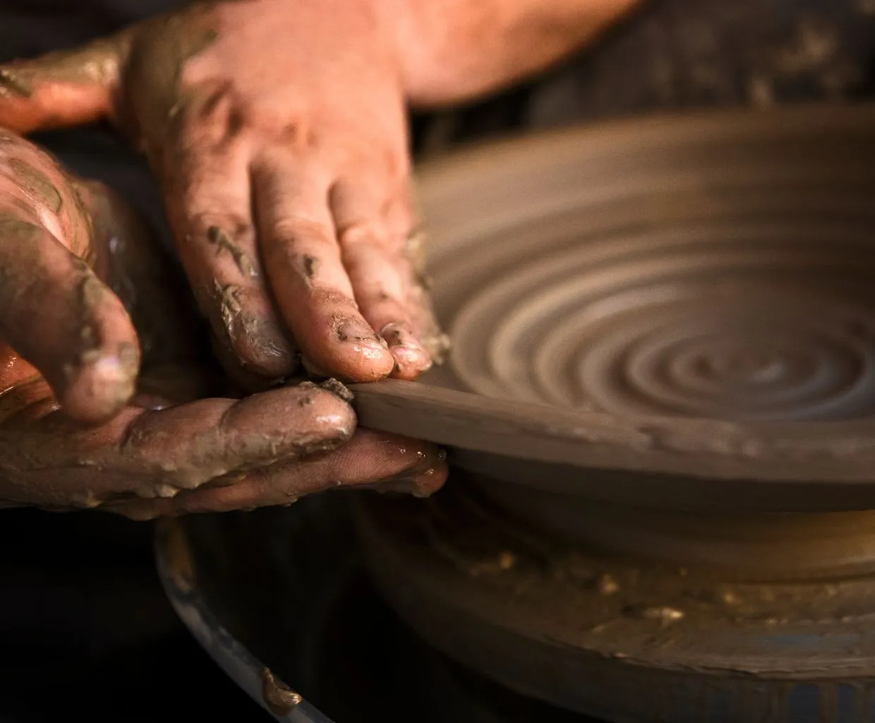 Manos de alfarero dando forma a una pieza en el torno