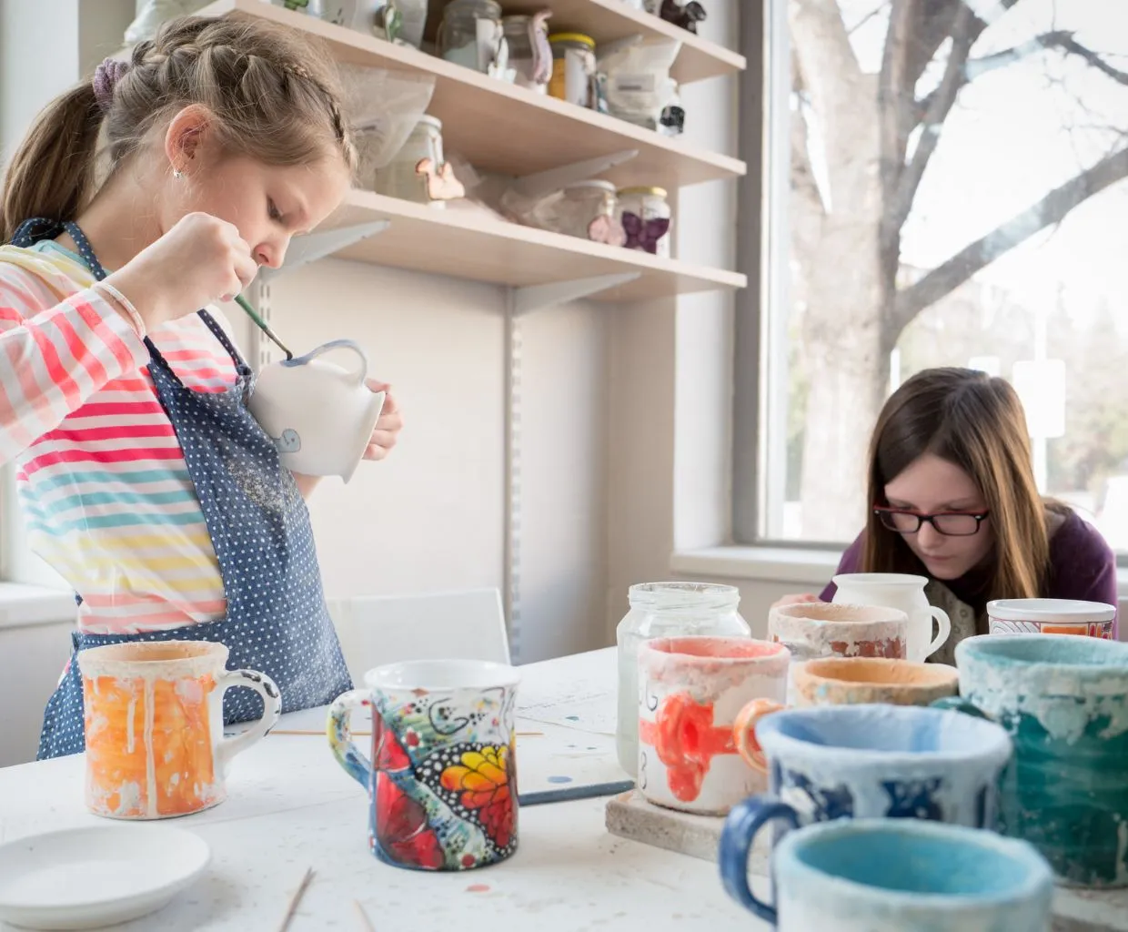 Niños pintando piezas de manualidades en una mesa