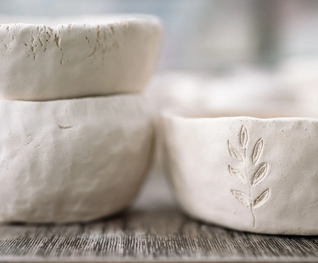 Cuencos de arcilla blanca con la huella de una hoja
