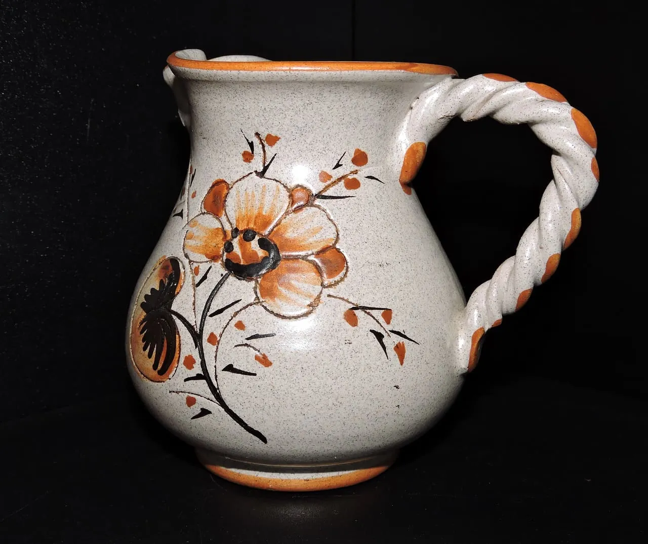 Jarra de cerámica con asa y flores pintadas